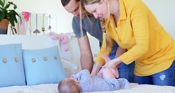 Parents changing diaper of their baby boy 