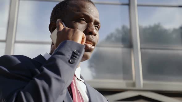 Busy Black  Businessman on The Street Talking with Smartphone