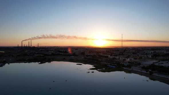 A Lake a Factory and a City at a Beautiful Sunset