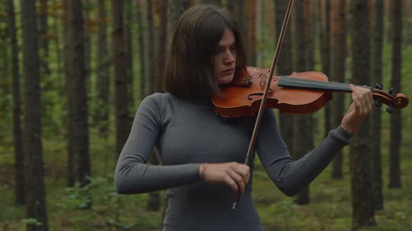 Woman Violinist Is Playing Among Trees