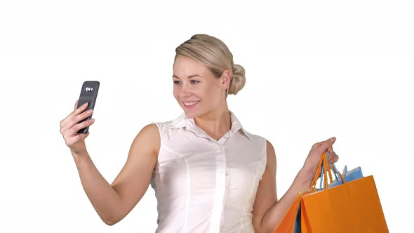 Sale, Consumerism, Technology and People Concept - Happy Young Woman with Smartphone and Shopping