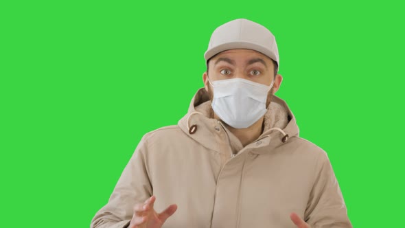 Coronavirus Protection Young Hipster Man Wearing Protective Mask Talking To Camera on a Green Screen