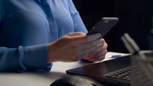 Businesswoman Calling on Smartphone at Dark Office