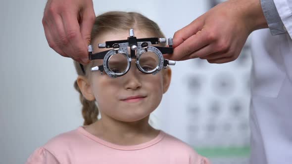 Optometrist Putting Special Glasses on Little Girl, Diagnosing Lazy Eye Illness