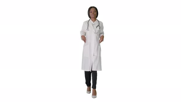 Sad African American Female Doctor Walking with Hands in Her Pockets on White Background