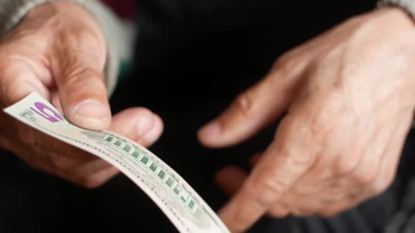 Close-up of male hands holding a 5 American dollar bill