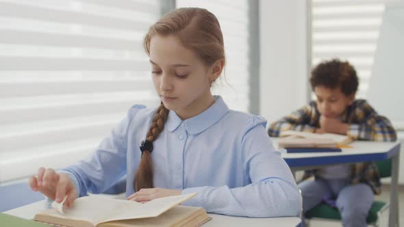 Caucasian School Girl Reading Textbook