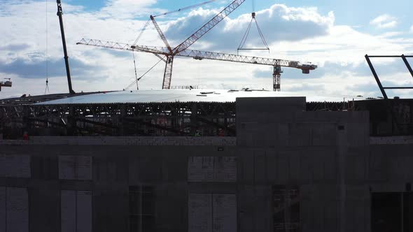Crane Carries Detail Over Stadium at Construction Site