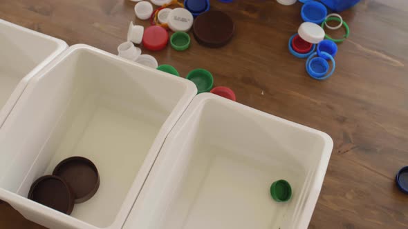 Unrecognizable Volunteer Sorting Multicolor Plastic Caps