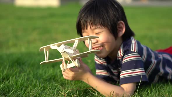 Cute Asian Child Playing Wooden Airplane In The Park Outdoors Slow Motion 