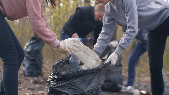 Women Putting Plastic Trash in a Bag