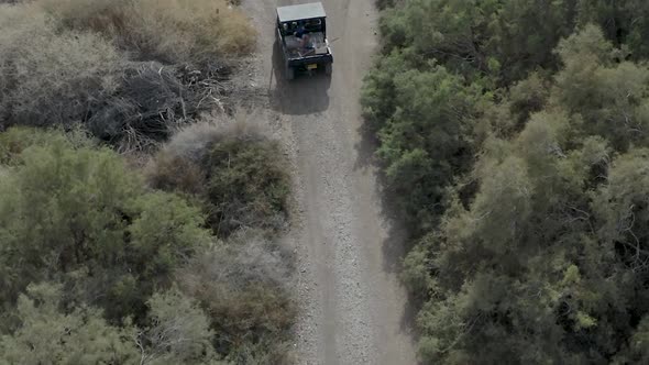 Buggy drive on a trail in a desert park, aerial footage following the buggy