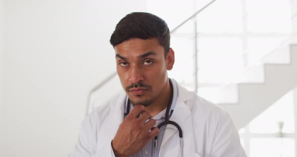 Portrait of happy hispanic male doctor having interview with patient at home