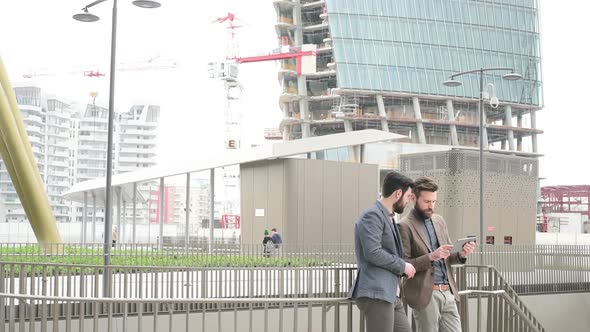 Two young bearded men business district using digital tablet