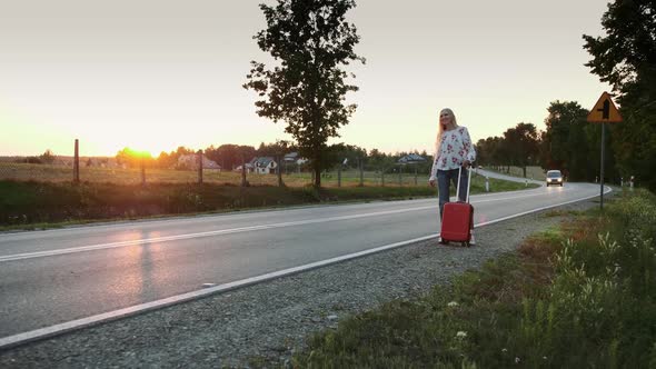 Young Woman Hitchhiking on Countryside Road.