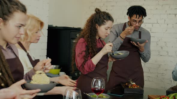 Group of Happy Men and Women Eating Delicious Meals After Culinary Master-class