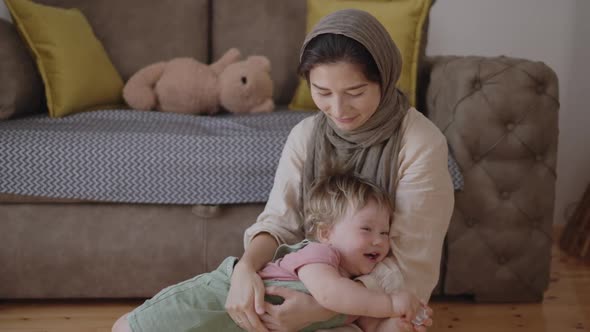 Adorable Infant Baby Boy Daughter Playing with Arabic Muslim Mom in Hijab at Home