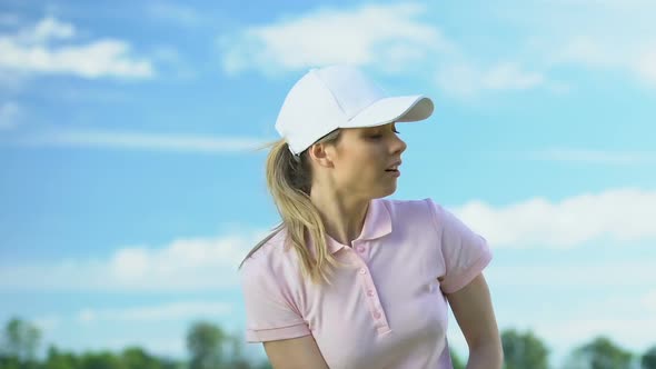 Nervous Woman Training to Swing and Hitting Balls Playing Golf on Country Course