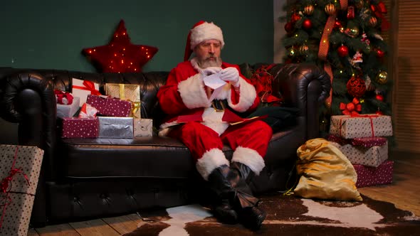 Santa Claus Reads Letters with Delight and a Smile on His Face