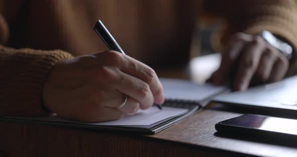 Close Up of Male Hands Taking Notes in Notebook