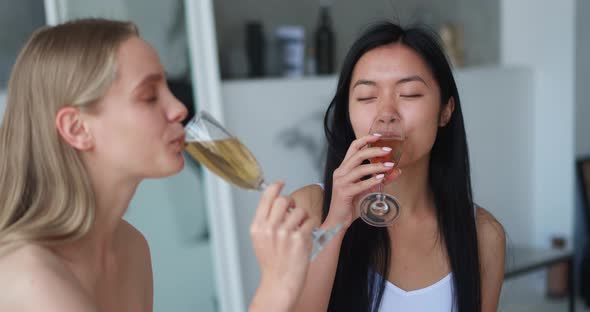 Closeup of Two Cheerful Beautiful Blonde and Brunette Women Chilling Together at Henparty in Home