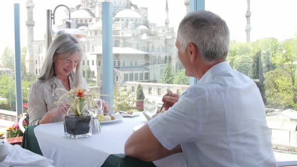 Senior couple enjoying a glass of wine and lunch overlooking the Blue Mosque, Istanbul, Turkey