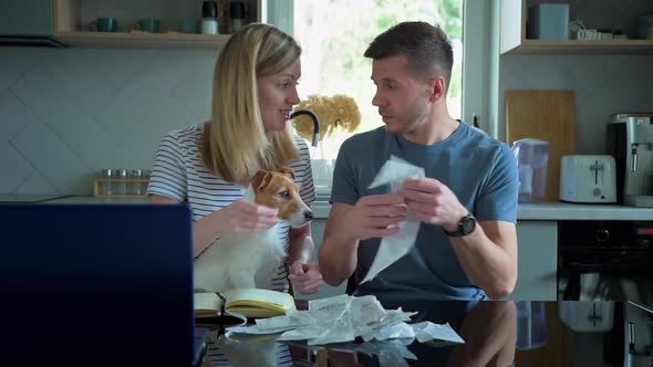 Man and Woman Looking at Payment Bills in the Kitchen