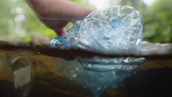 Used plastic pollutes water in nature, a close-up of cleaning plastic bottles and glasses