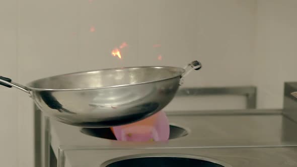 Cook Prepares the Vegetables on a Burning Frying Pan