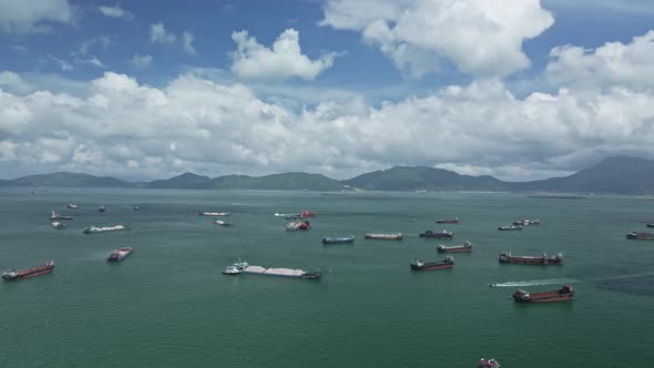 A pan shot of a sea in Tuen Mun where cargo and sand boat idling in the sea. Hong Kong.