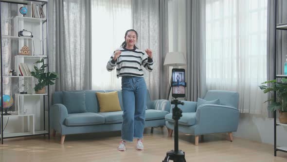 Asian Woman Dancing While Shooting Video Content For Social Networks With A Smartphone Camera