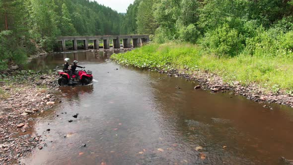 Drone Shot of Couple Driving Quad Bike through River