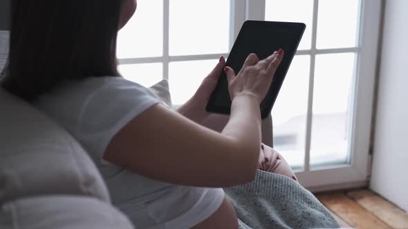 Pregnant Woman Using a Digital Tablet