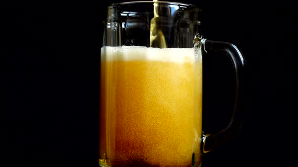 Pouring beer into a glass on a black background.