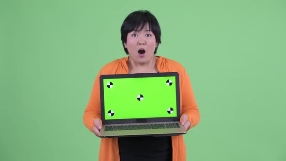 Happy Young Overweight Asian Woman Showing Laptop and Looking Surprised Ready for Gym