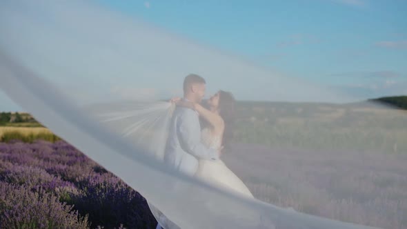 Newlyweds in Love Embrace Tenderly in a Lavender Field