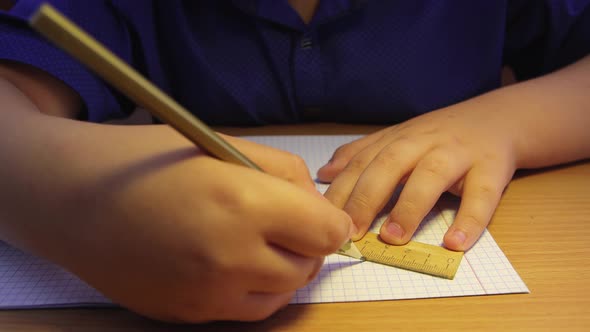 Closeup Hands of a High School Student Draw a Line Along a Ruler