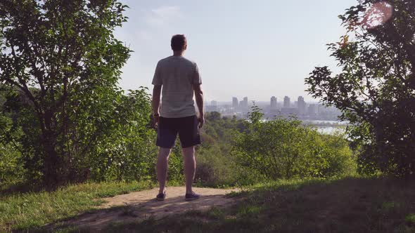 Guy Looks on Urban Landscape From the Top.