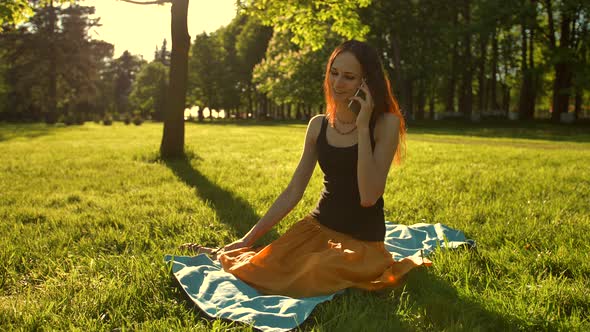 Woman Talking By Selfphone Call Outdoors in the Park