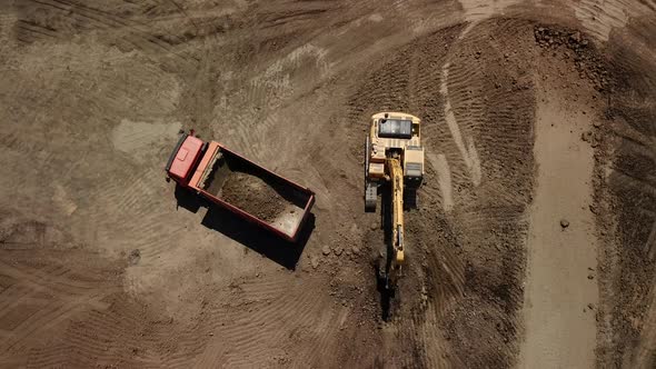 Aerial View of Excavator Pours Sand Into the Truck