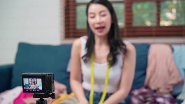 Asian stylist fashion influencer designer women using camera streaming and live to sell clothes.