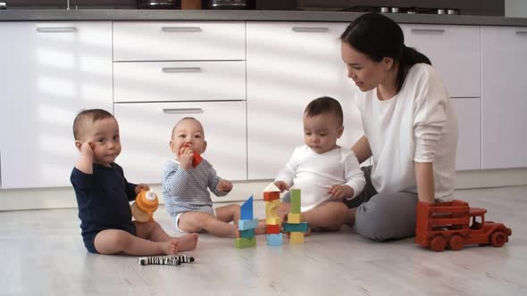 Happy Asian Mother Playing with her Triplets