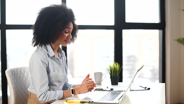 A Young Biracial Woman Is Using a Laptop Indoor