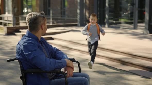 Close View of the Disabled Father Waiting His Son From the School alt