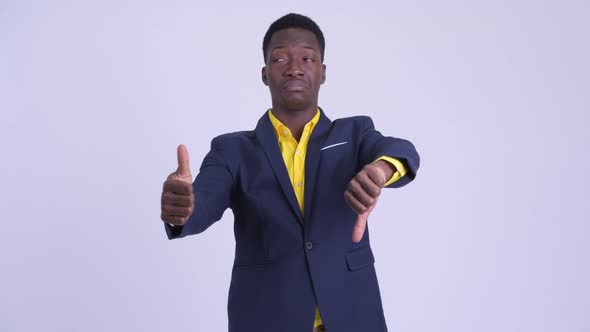 Young Confused African Businessman Choosing Between Thumbs Up and Thumbs Down