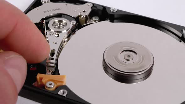 Finger Touches To the Recording Head Open Hard Drive. Hard Disk Drive Inside