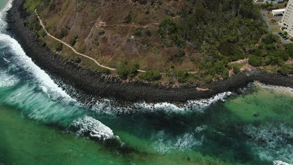 Waves crashing shoreline at  Burleigh Heads, Gold Coast. Panoramic aerial, slow motion