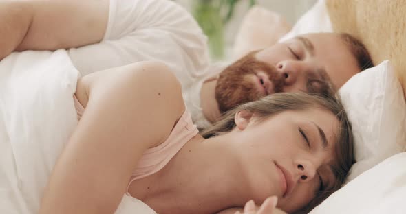 Portrait of Young Loving Family Cuddling in Bed While Sleeping in Early Morning. Handsome Bearded