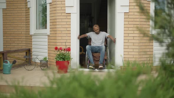 Disabled African American Man Having Troubles Riding Out the House on Wheelchair