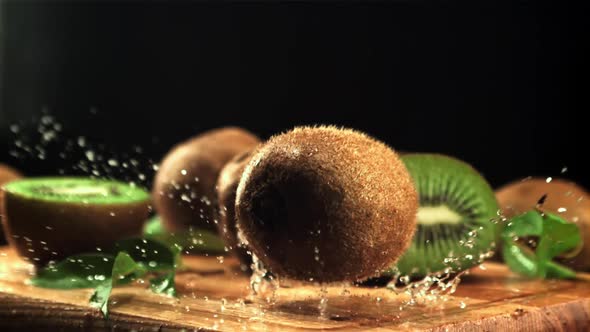 A Ripe Kiwi Falls on a Cutting Board with Splashes of Water